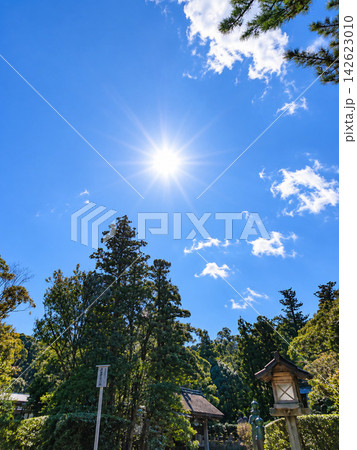 青空に輝く太陽と伊勢神宮の木々・灯籠 青空に輝く太陽と伊勢神宮の木々・灯籠 142623010