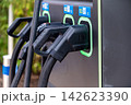 Electric car charging station with multiple connectors in a public area 142623390