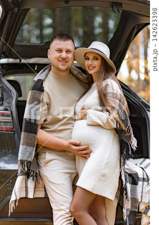 A happy couple poses together in the forest, celebrating their pregnancy and looking forward to the future A happy couple poses together in the forest, celebrating their pregnancy and looking forward to the future 142623398