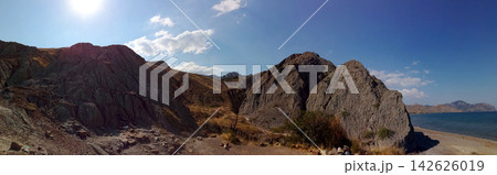 panoramic view of dry clay hills and mountains near the sea coast under bright sunlight panoramic view of dry clay hills and mountains near the sea coast under bright sunlight 142626019
