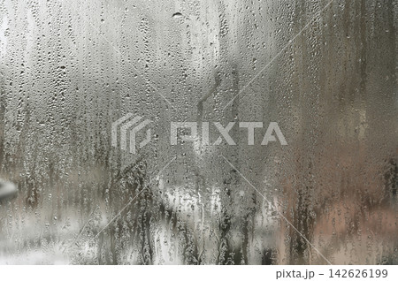 Wet glass surface with water drops creates abstract background Wet glass surface with water drops creates abstract background 142626199