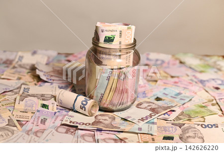 Ukrainian currency in glass jar represents savings, money reserve and personal finance planning. 142626220