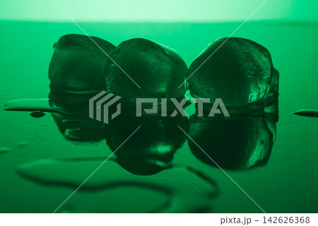 Pure clean Ice Cubes Melting On Mirror Surface In Neon Green Light Still Life Pure clean Ice Cubes Melting On Mirror Surface In Neon Green Light Still Life 142626368