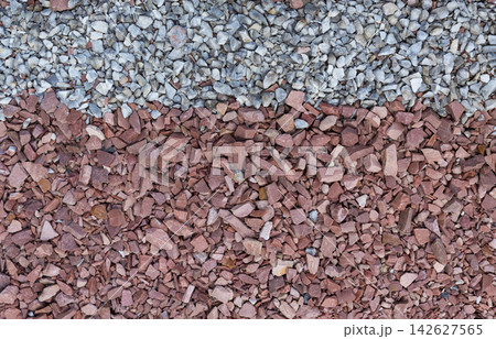Abstract close-up texture of small crushed red and white stones arranged in contrasting horizontal bands. Suitable as background for landscaping, construction, geology, decorative aggregate concepts Abstract close-up texture of small crushed red and white stones arranged in contrasting horizontal bands. Suitable as background for landscaping, construction, geology, decorative aggregate concepts 142627565