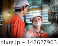 The engineer checks the parts coming out of the machine. 142627903