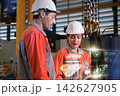 The engineer checks the parts coming out of the machine. 142627905
