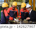 The engineer checks the parts coming out of the machine. 142627907
