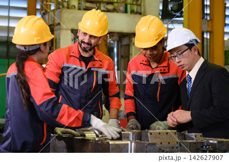 The engineer checks the parts coming out of the machine. The engineer checks the parts coming out of the machine. 142627907