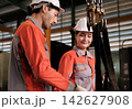 The engineer checks the parts coming out of the machine. 142627908
