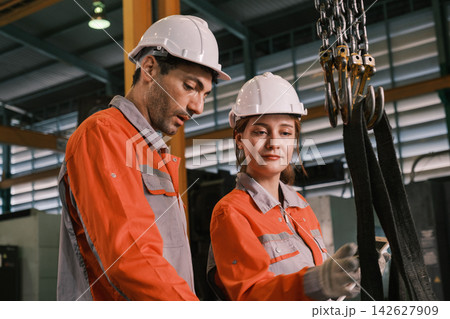 The engineer checks the parts coming out of the machine. 142627909