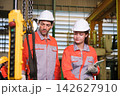 The engineer checks the parts coming out of the machine. 142627910