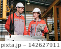 The engineer checks the parts coming out of the machine. 142627911