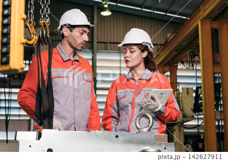 The engineer checks the parts coming out of the machine. 142627911