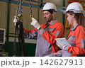 The engineer checks the parts coming out of the machine. 142627913