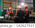 The engineer checks the parts coming out of the machine. 142627915