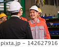 The engineer checks the parts coming out of the machine. 142627916