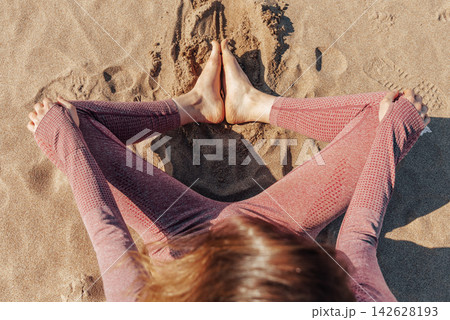 Woman doing yoga on sandy beach, female sport background sea blue sky, sunny day 142628193