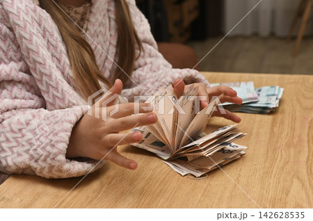 Small child hands counting money bills. 142628535