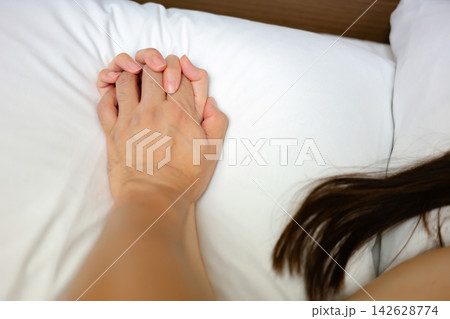 ベッドで手を握る男女 ベッドで手を握る男女 142628774