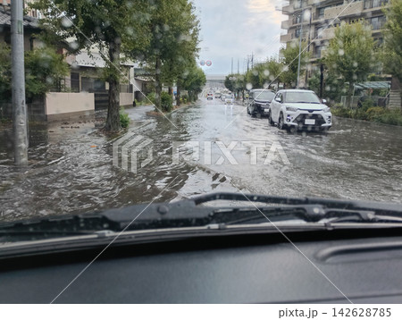 冠水した道路を走る自動車 (走行中撮影) 冠水した道路を走る自動車 (走行中撮影) 142628785