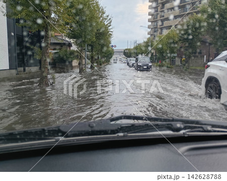 冠水した道路を走る自動車 (走行中撮影) 冠水した道路を走る自動車 (走行中撮影) 142628788
