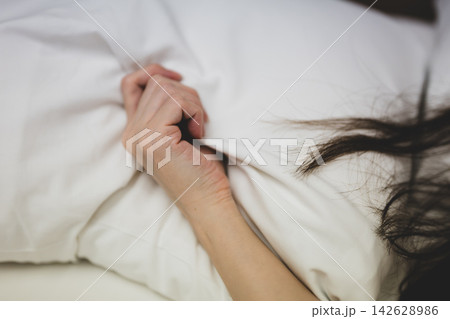 ベッドでシーツを握り締める女性 ベッドでシーツを握り締める女性 142628986