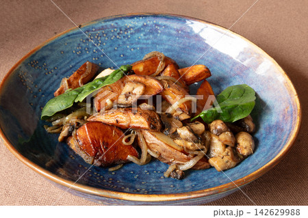 Mushrooms and sweet potatoes cooked with spinach on a blue plate 142629988