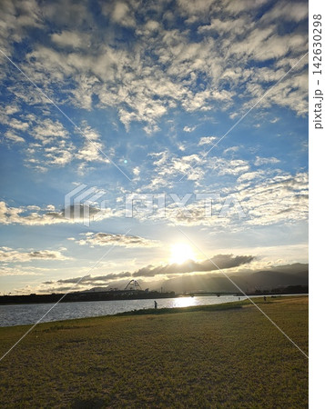 夕日が輝く河川敷と広大なうろこ雲の青空(甲子園浜海浜公園) 夕日が輝く河川敷と広大なうろこ雲の青空(甲子園浜海浜公園) 142630298