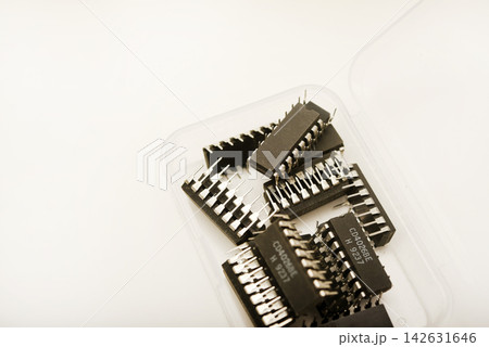 A plastic box with microchips on a white background. A container with electronics. Chips. 142631646