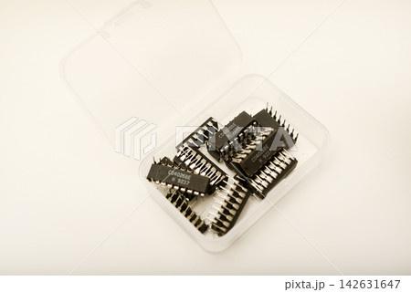A plastic box with microchips on a white background. A container with electronics. Chips. 142631647