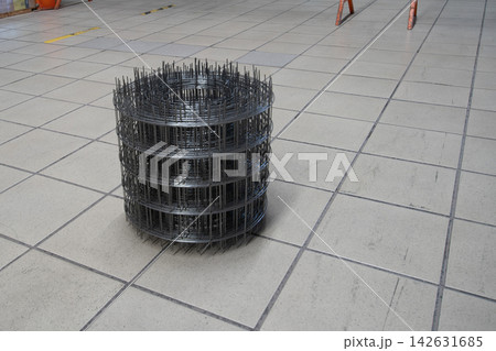 Metal wire mesh used in construction placed on a tiled floor at a building site during day time 142631685