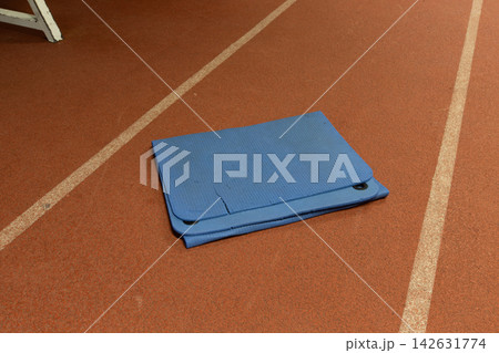 Mat placed on the track surface in a gym area during a training session for athletes before a competition Mat placed on the track surface in a gym area during a training session for athletes before a competition 142631774