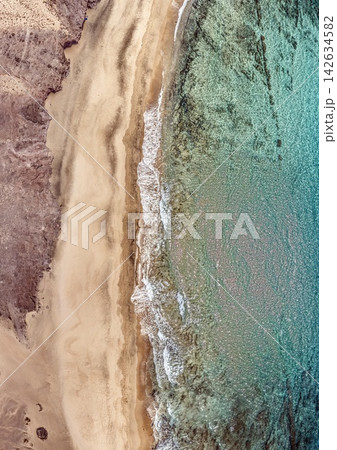 Top down aerial view of sandy beach and clear turquoise ocean water 142634582