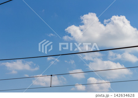 青空を横断する鉄道の架線と浮かぶ柔らかな白雲 青空を横断する鉄道の架線と浮かぶ柔らかな白雲 142634628