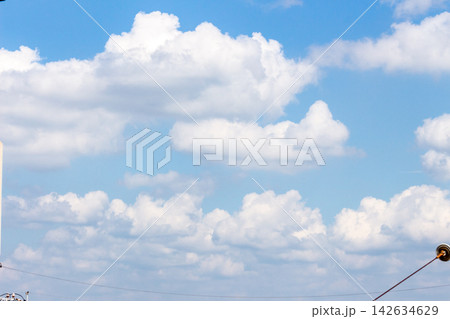 電柱と架線を配した青空に広がる豊かな白雲と夏空 電柱と架線を配した青空に広がる豊かな白雲と夏空 142634629