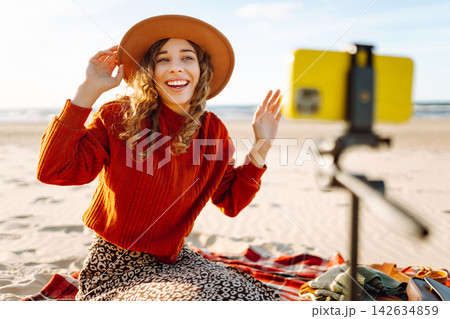 Style woman using smartphone with stabilizer, taking pictures in on sea beach. Woman creates content Style woman using smartphone with stabilizer, taking pictures in on sea beach. Woman creates content 142634859