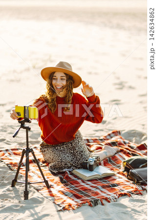 Style woman using smartphone with stabilizer, taking pictures in on sea beach. Woman creates content Style woman using smartphone with stabilizer, taking pictures in on sea beach. Woman creates content 142634862