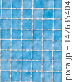 Blue square tiles creating a mosaic pattern surface 142635404