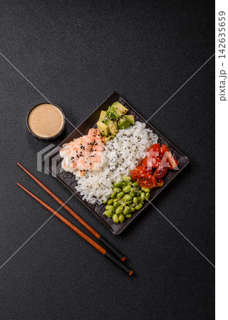 An Asian style bowl with shrimp, edamame, tomatoes, and wakame. A shrimp and vegetable bowl 142635659