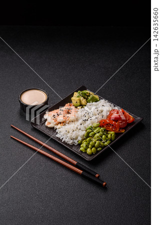 An Asian style bowl with shrimp, edamame, tomatoes, and wakame. A shrimp and vegetable bowl 142635660