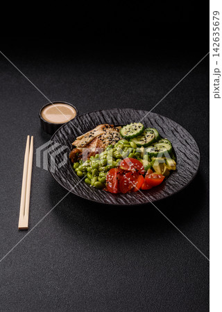 An Asian style bowl with eel, edamame, avocado, tomatoes, and lettuce. A eel and vegetable bowl An Asian style bowl with eel, edamame, avocado, tomatoes, and lettuce. A eel and vegetable bowl 142635679