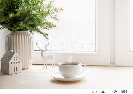 Christmas morning coffee by bright winter window Christmas morning coffee by bright winter window 142636043