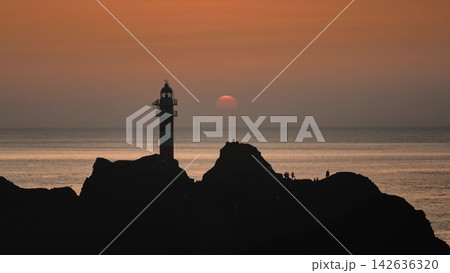 Punta de Teno lighthouse silhouette in Tenerife, with Atlantic Ocean view under colorful evening sky. Drone flight panorama. Canary Islands: Tourists enjoy vibrant orange sunset landscape Punta de Teno lighthouse silhouette in Tenerife, with Atlantic Ocean view under colorful evening sky. Drone flight panorama. Canary Islands: Tourists enjoy vibrant orange sunset landscape 142636320