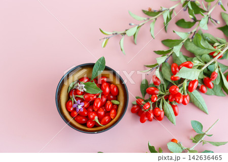 Fresh goji berries in bowl on soft pink background Fresh goji berries in bowl on soft pink background 142636465