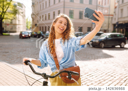Young woman using mobile phone at the city. Telecommunications, video call conference. Selfie time. 142636988