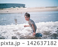夏の海の波打ち際で服のまま濡れて笑う男の子 142637182