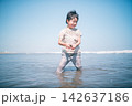 夏の海の浅瀬で貝殻を拾って笑う男の子 142637186