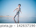 夏の海の波打ち際で砂まみれになって遊ぶ男の子 142637190