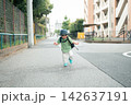 帽子とリュックで住宅街の道を笑顔で走る男の子 142637191