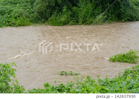 大雨で増水した濁った川の流れ 大雨で増水した濁った川の流れ 142637930
